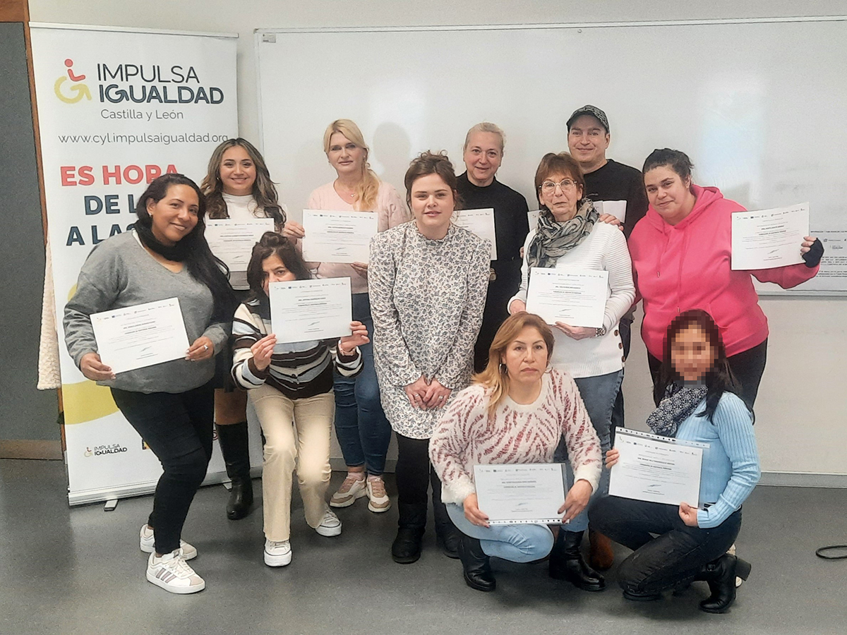 Con un roll-up de fondo de IMPULSA IGUALDAD CyL, foto del grupo de participantes posando con su diploma y Nuria Témez, la orientadora laboral del proyecto, en el centro.