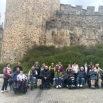 Foto de familia de los participantes en la experiencia turística accesible a Ponferrada, realizada en 2024, frente al castillo.