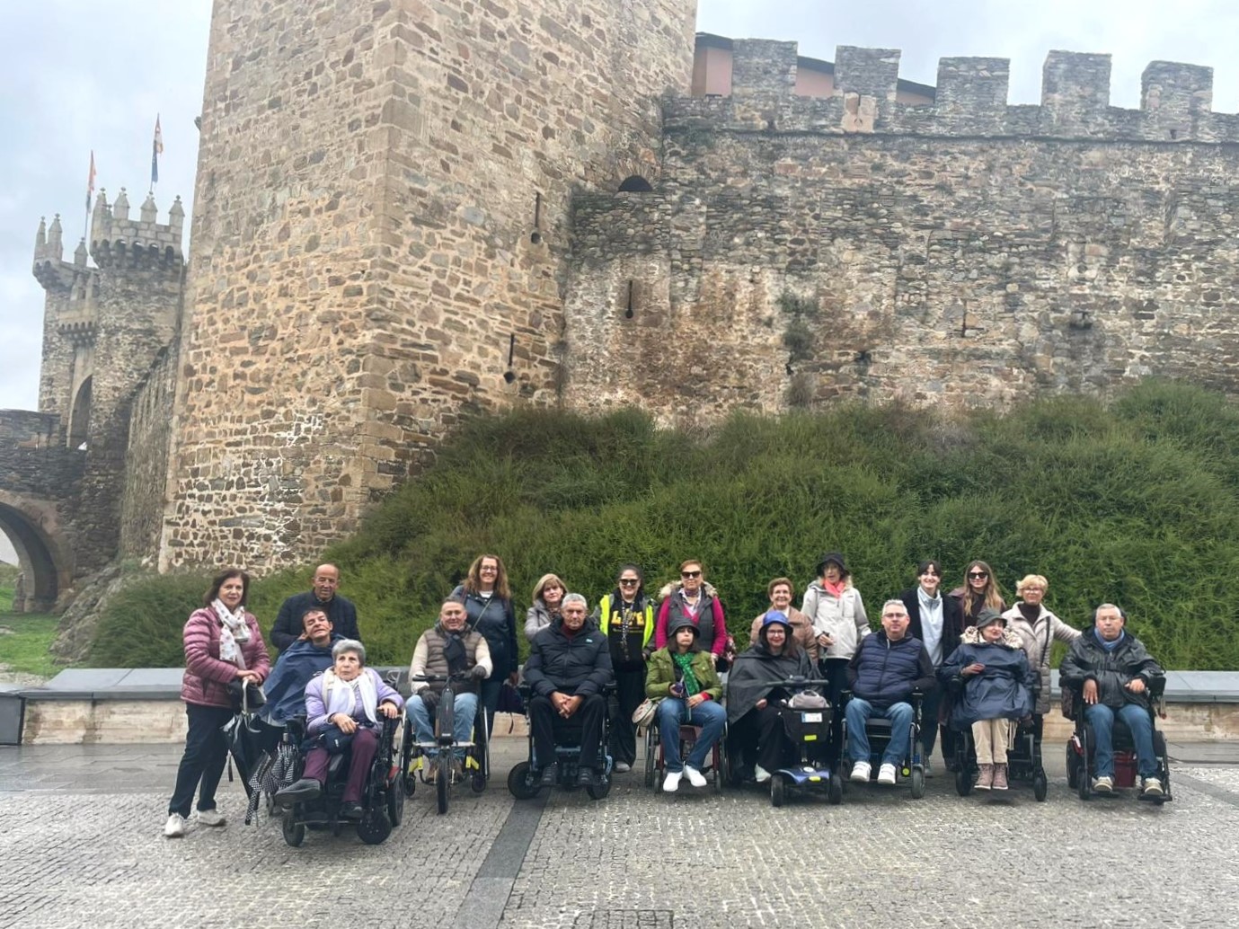 Foto de familia de los participantes en la experiencia turística accesible a Ponferrada, realizada en 2024, frente al castillo.