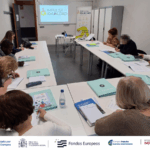 Participantes del proyecto escribiendo en el aula de las sesiones presenciales con el primer taller grupal de presentación. Abajo, logos organizadores y financiadores.