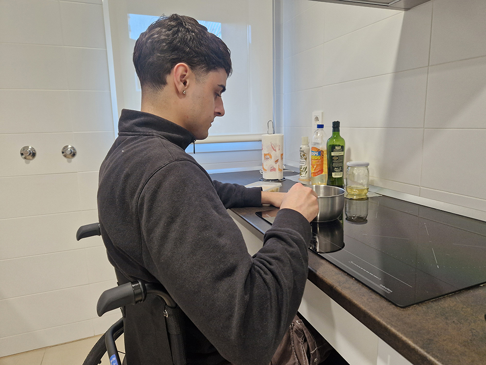 Eloy en la vitrocerámica con un cazo con una encimera adaptada.