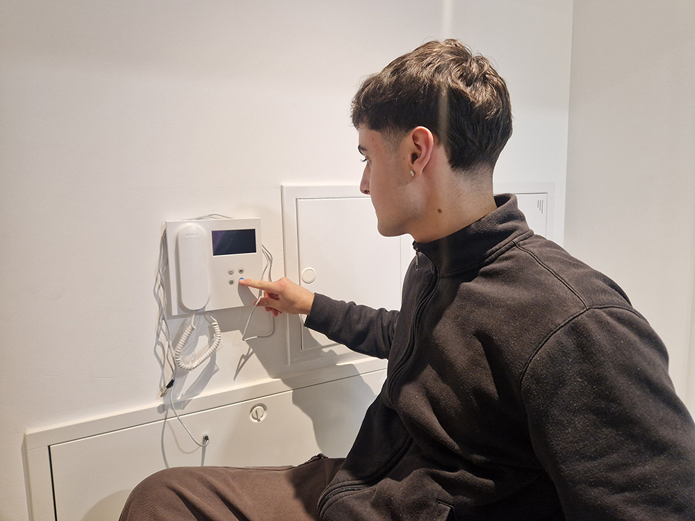 Eloy abriendo el portal con un telefonillo adaptado en altura.