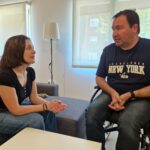 La responsable del SIAP y del proyecto 'Viviendas de transición a la vida independiente', Laura Cano, charla en el salón de uno de los pisos accesibles, con Miguel Ángel San José, uno de los participantes.