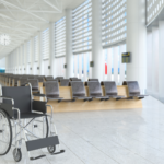 Una sala de espera de un aeropuerto con una silla de ruedas en primer plano.
